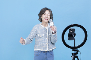 힙노년_핸드폰 보며 노래 부르는 시니어 사진 이미지