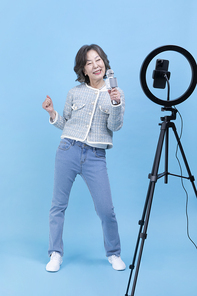 힙노년_핸드폰 보며 노래 부르는 시니어 사진 이미지