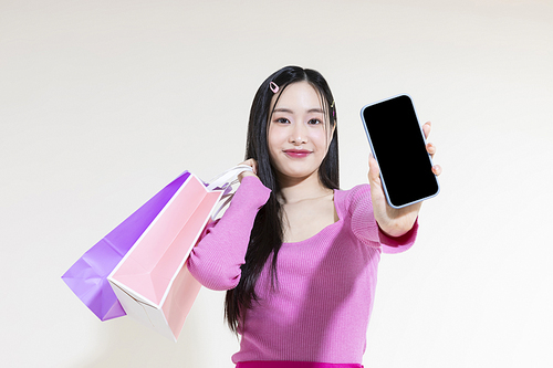 Y2K 라이프스타일_쇼핑백과 스마트폰 들고 있는 여성 컨셉 사진