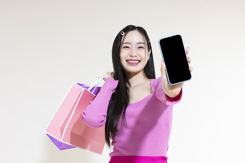 Y2K 라이프스타일_스마트폰과 쇼핑백 들고 있는 여성 컨셉 사진