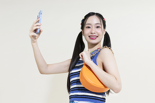 Y2K 라이프스타일_핸드백과 스마트폰 들고 있는 여성 컨셉 사진