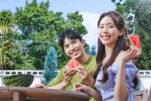 여름일상_야외에서 수박을 먹는 남녀 사진 이미지