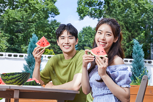 여름일상_야외에서 수박을 먹는 남녀 사진 이미지