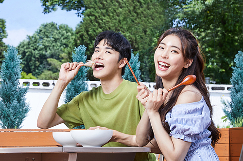 여름일상_앉아서 보양식을 먹는 남녀 사진 이미지