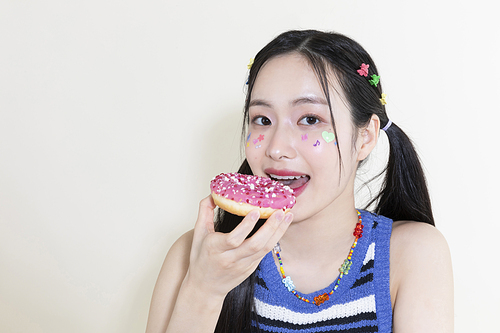 Y2K라이프스타일_도너츠 먹으려고 들고 있는 여성 사진 이미지