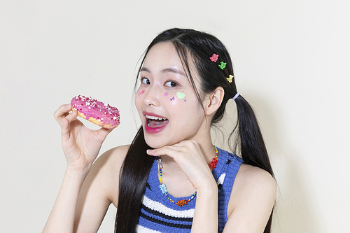 Y2K라이프스타일_도너츠 먹으려고 들고 있는 여성 사진 이미지