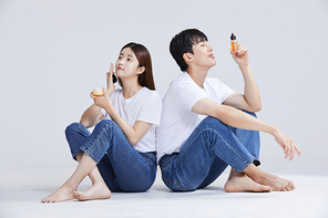 화장품을 들고 앉아있는 남자와 여자 사진 이미지