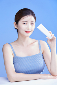 썬크림을 들고 있는 여자 사진 이미지