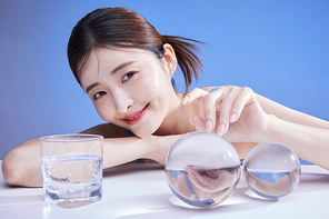 크리스탈을 만지며 웃는 여자 사진 이미지