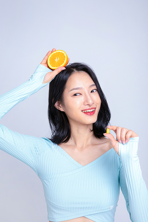 건강한 식사_알약과 오렌지를 들고있는 여성 사진 이미지