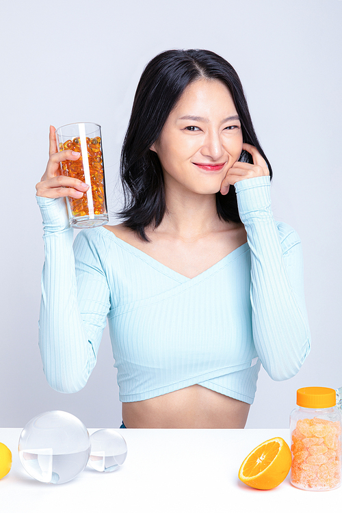 건강한 식사_컵에 담긴 알약을 들고있는 여성 사진 이미지