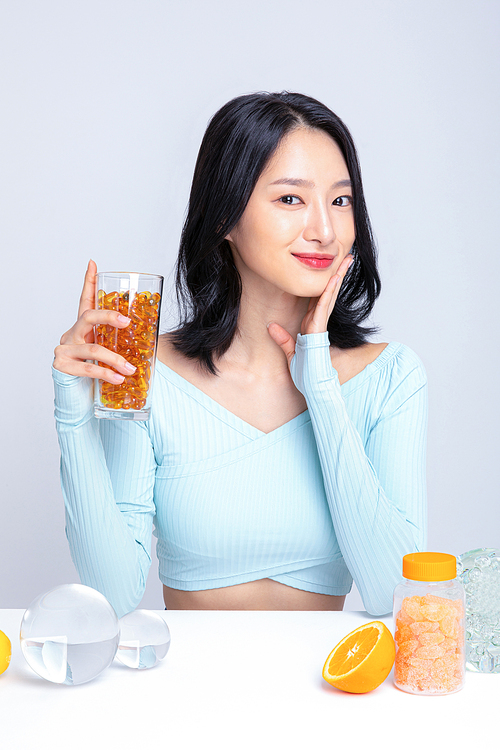 건강한 식사_컵에 담긴 알약을 들고있는 여성 사진 이미지