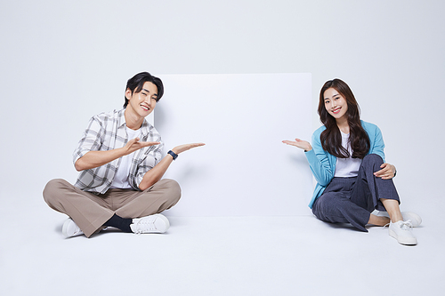 협동 비즈니스_양반다리를 하고 비어있는 메시지 종이 옆에 앉아있는 남자와 여자 사진 이미지