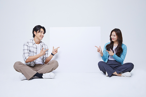 협동 비즈니스_양반다리를 하고 비어있는 메시지 종이 옆에 앉아있는 남자와 여자 사진 이미지