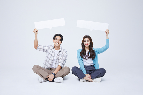 협동 비즈니스_양반다리를 하고 비어있는 메시지 종이를 들고 앉아있는 남자와 여자 사진 이미지