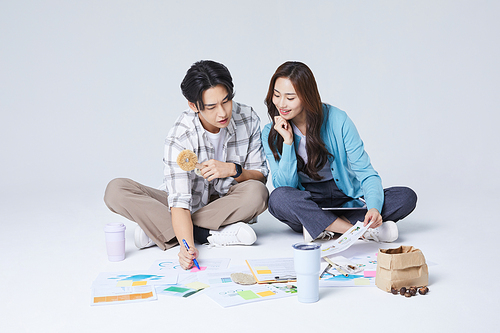 협동 비즈니스_양반다리를 하고 이야기를 나누는 앉아있는 남자와 여자 사진 이미지