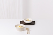 흰탁자위에 떡국 두 그릇과 수저가 놓여있는 사진