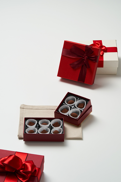 개별포장된 초콜릿이 담긴 박스가 있고 주변에 여러 개의 선물상자가 있다