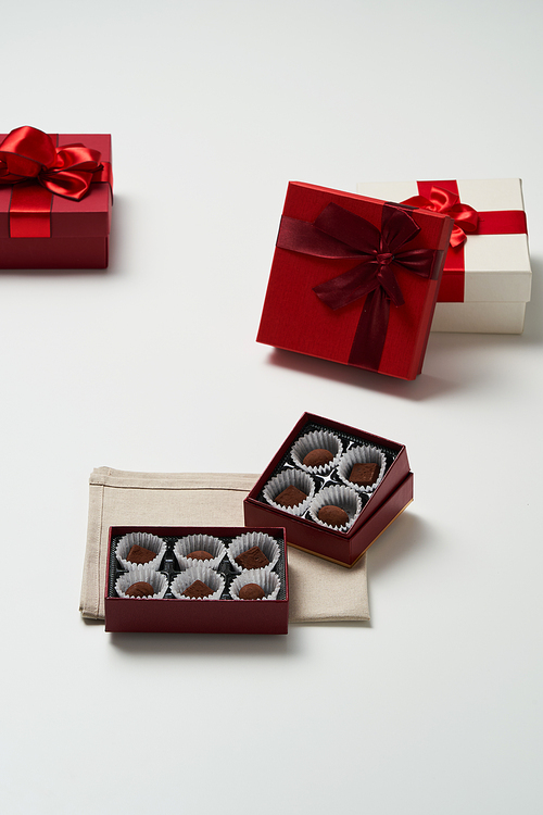 개별포장된 초콜릿이 담긴 박스가 있고 주변에 여러 개의 선물상자가 있다
