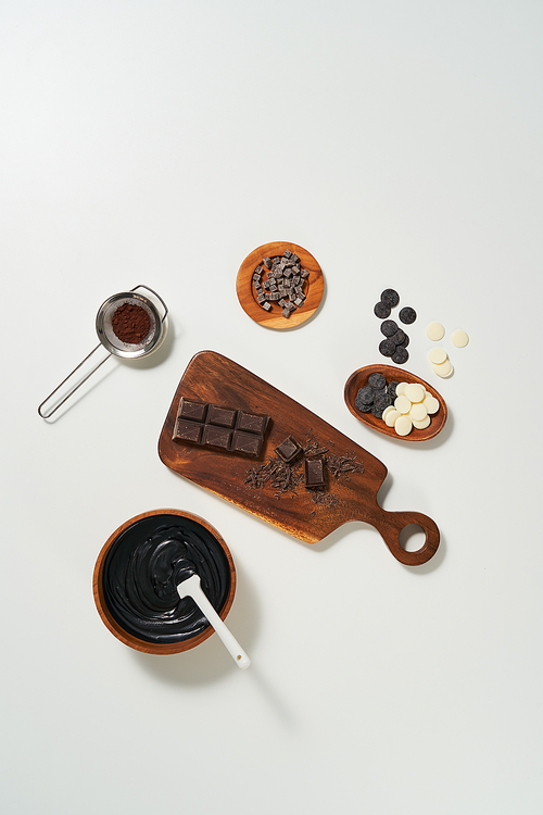 녹인 초콜릿과 여러종류의 초콜릿이 접시와 도마에 담겨있다