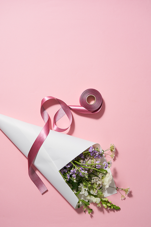 핑크배경의 종이포장된 꽃다발