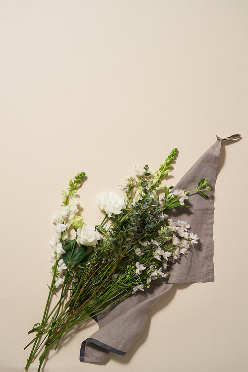 천 위에 놓인 싱그러운 초록잎사귀의 하얀꽃 한묶음