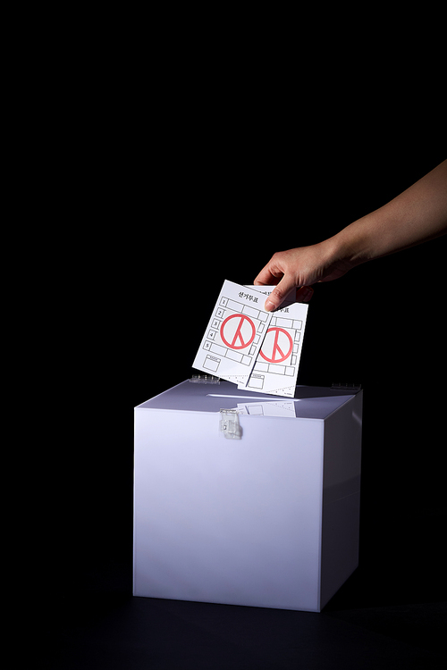 투표함에 여러장의 투표용지를 넣는 손