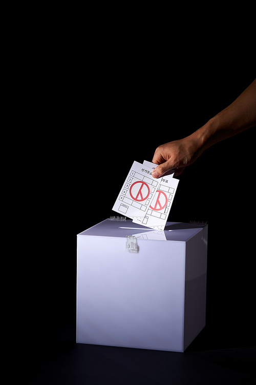 투표함에 여러장의 투표용지를 넣는 손