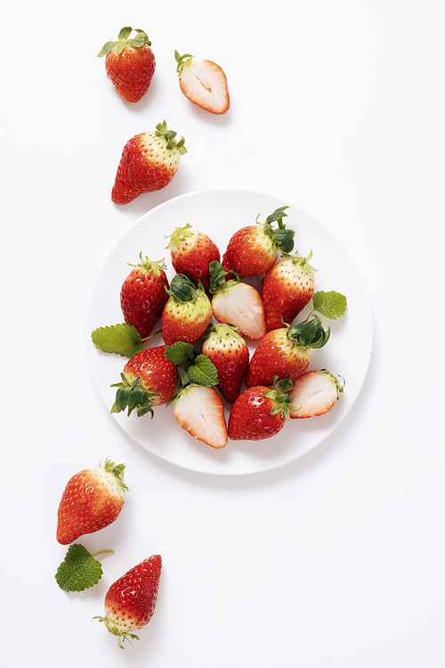 접시 안팎으로 놓인 싱싱한 딸기