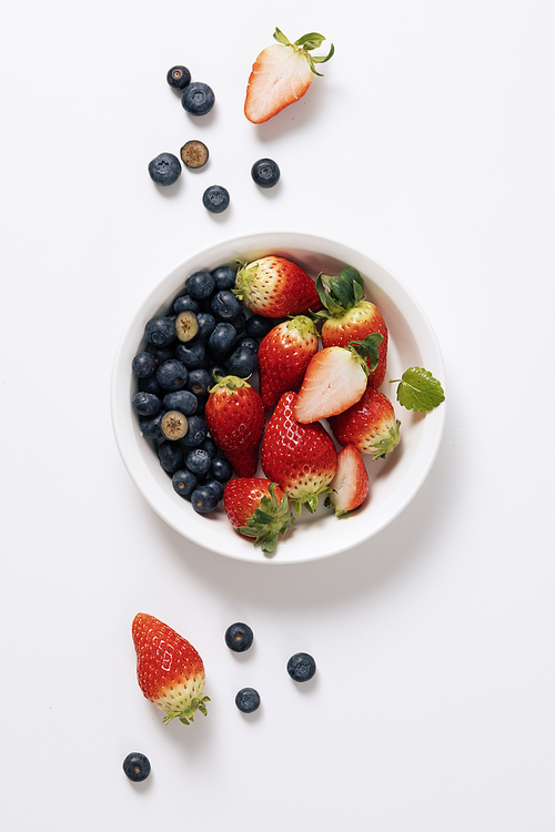 흰 접시에 가득담긴 블루베리와 딸기