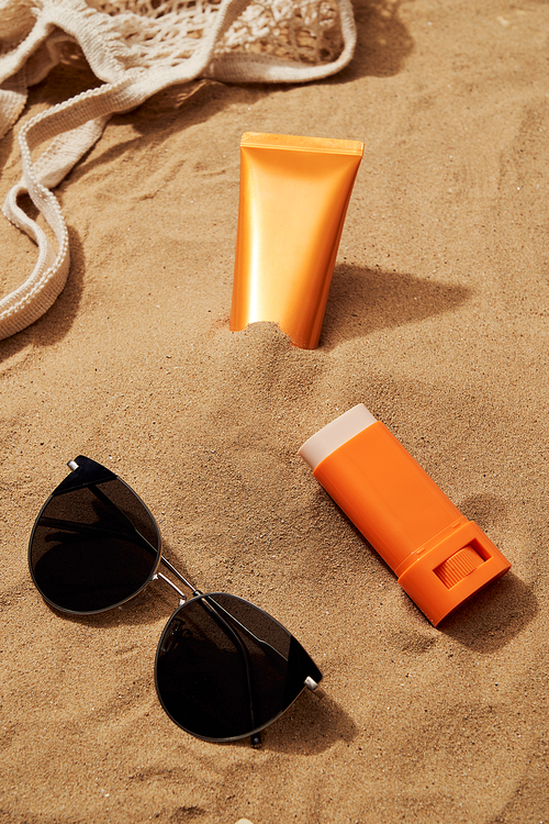 선글라스와 함께 모래위에 있는 자외선 차단제