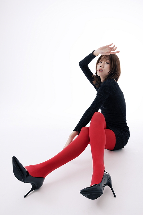 블랙 원피스와 레드레깅스를 입고 바닥에 앉아 포즈를 취하는 한국인 여성