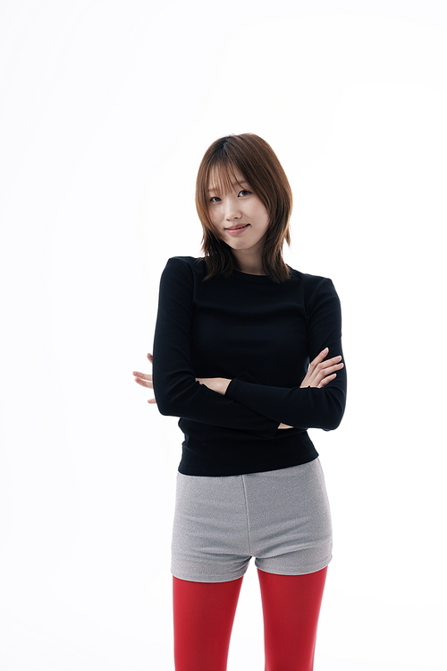 마이크로 쇼츠 의상을 입고 팔짱을 낀 한국인 여성