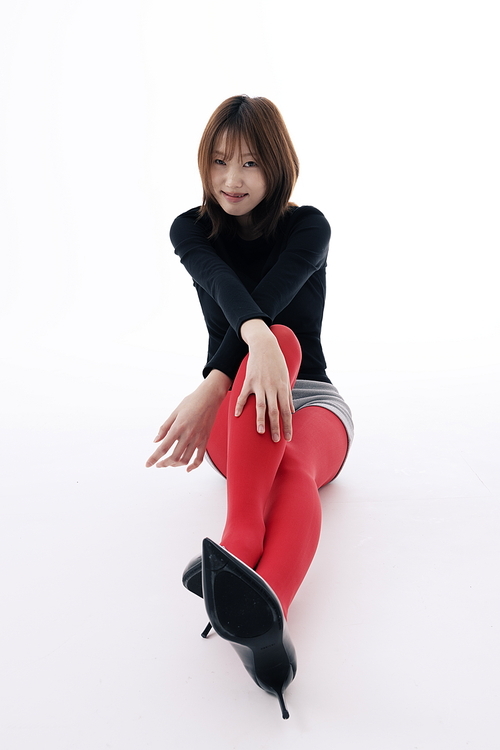 레드레깅스를 입고 바닥에 앉아서 포즈를 취하는 한국인 여성