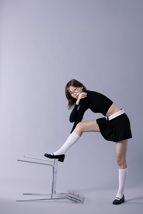 긱시크룩을 입고 넘어진 의자에 발을 올리는 20대 한국인 여성
