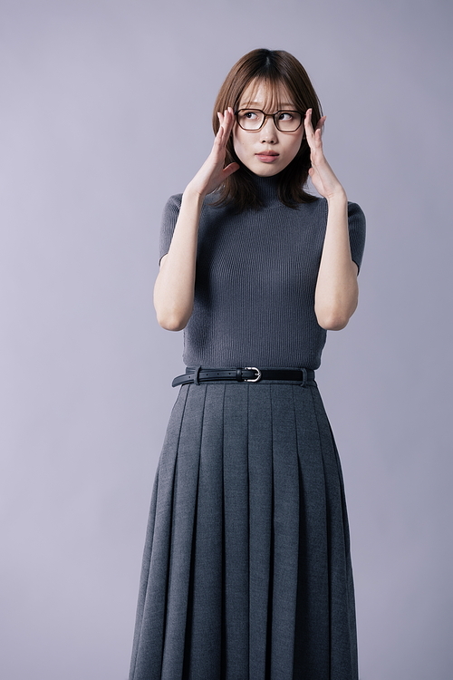 긱시크룩을 입고 양손으로 안경테를 만지는 20대 한국인 여성