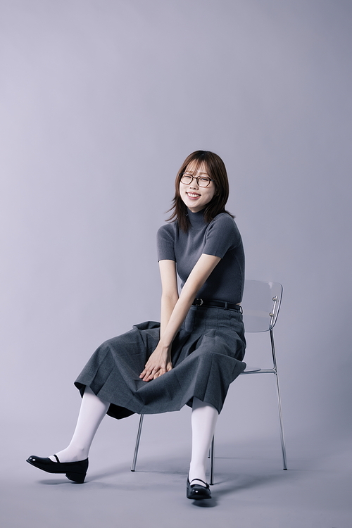 긱시크룩 스타일을 하고 의자에 앉아 포즈를 하는 20대 한국인 여성