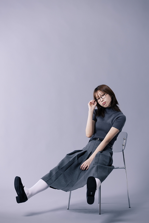 긱시크룩 스타일을 하고 다리를 뻗는채 의자에 앉아있는 20대 한국인 여성