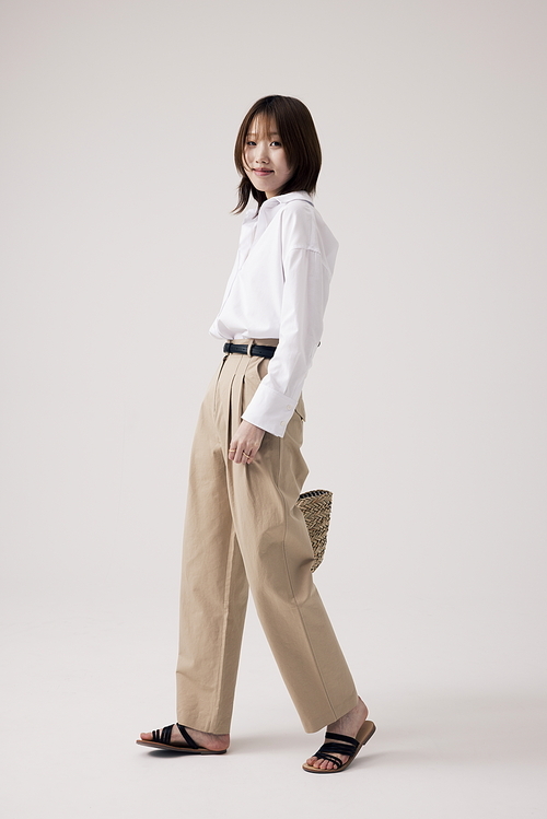 흰셔츠와 베이지 바지를 입은 한국인 여성