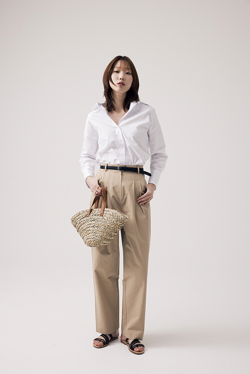 깔끔한 의상에 베이지 가방을 들고 있는 한국인 여성