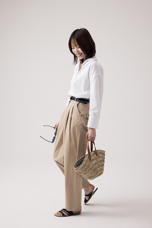선글라스를 손에 들고 걷는 포즈를 취하는 한국인 여성