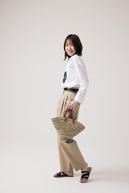 흰셔츠와 베이지 바지를 입고 포즈를 취하는 한국인 여성
