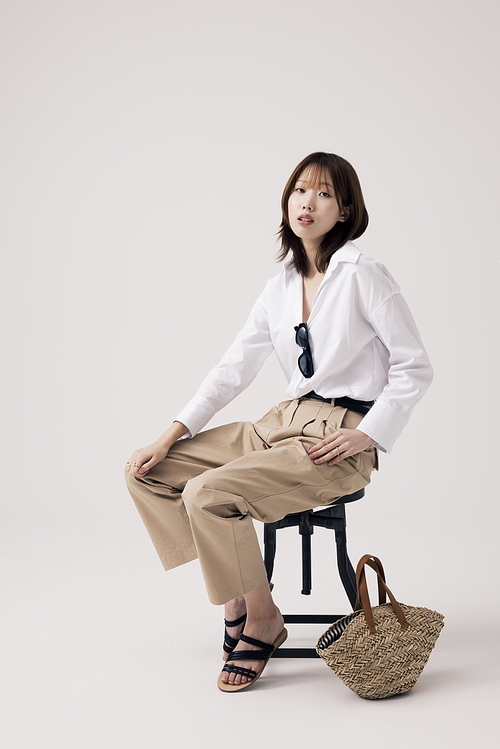 트렌디한 의상을 입고 의자에 앉아있는 한국인 여성