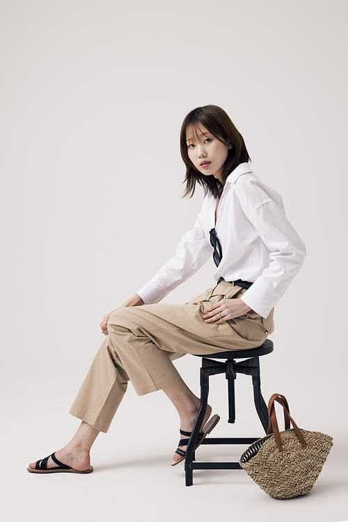트렌디한 의상을 입고 의자에 앉아있는 한국인 여성