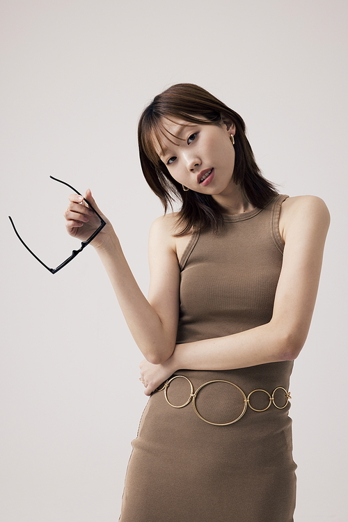 니트원피스를 입고 선들라스를 들고 있는 한국인 여성