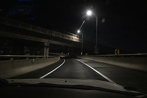 어두운 도로를 달리는 자동차