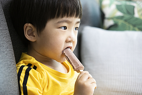 막대 아이스크림을 먹는 어린이