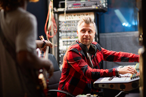 Sound operator looking at musician during recording