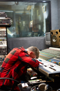 Tired deejay sleeping just right on soundboard in studio