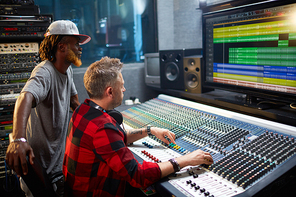 Two sound operators checking and adjusting frequency of sounds